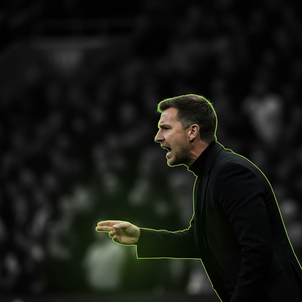 Newcastle United manager Eddie Howe on the touchline, bathed in a dramatic lime green and dark light, looking focused.